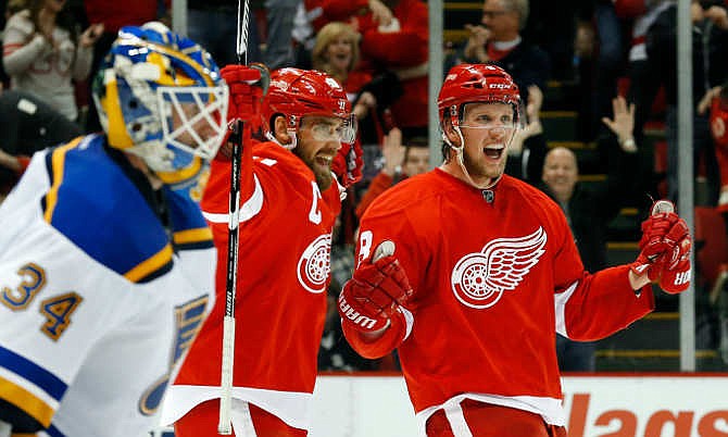 Detroit Red Wings' Justin Abdelkader, right, celebrates with teammate Henrik Zetterberg, center, after scoring against St. Louis Blues goalie Jake Allen (34) in overtime of an NHL hockey game in Detroit, Sunday, March 22, 2015. Detroit won 2-1. 