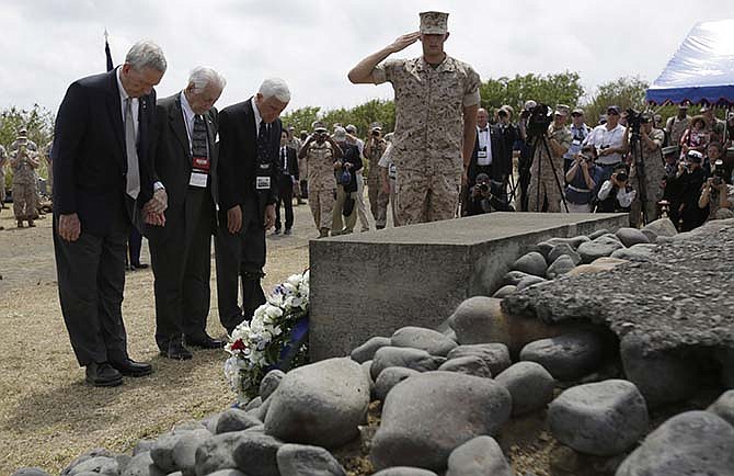U.S. veterans pay respect at the Iwo Jima battle monument during a ceremony commemorating the 70th anniversary of the Battle of Iwo Jima on Iwo Jima, now known officially as Ioto, Japan Saturday, March 21, 2015. 