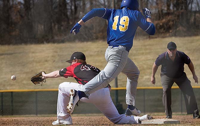 Fatima's Will Robertson makes it to first base as Bret Jaegers of the Jays waits on the ball on Saturday, March 21, 2015, at Vivion Field in Jefferson City.