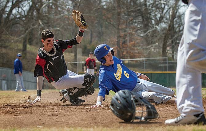 Zach Hudspeth of Fatima scores the first run of the game past Jays catcher Adam Grunden during Saturday's contest at Vivion Field in Jefferson City.