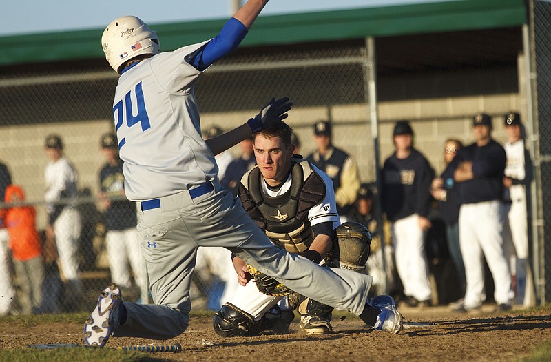 Helias catcher Alex Barton waits to tag out Boonville's Riley Lang after taking a throw from Kale Gerstner to end the top of the seventh inning of Thursday's game at the American Legion Post 5 Sports Complex.