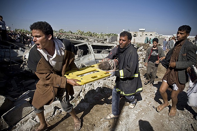 People carry the body of a child they uncovered from under the rubble of houses destroyed by Saudi airstrikes near Sanaa Airport, Yemen, Thursday. Saudi Arabia launched airstrikes Thursday targeting military installations in Yemen held by Shiite rebels who were taking over a key port city in the country's south and had driven the embattled president to flee by sea, security officials said. 