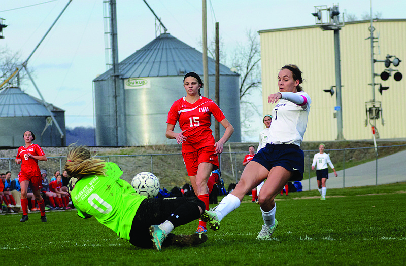 Sydnee Kliethermes of Helias lofts a shot for a goal over the Incarnate Word Academy keeper during Friday night's game at the 179 Soccer Park.