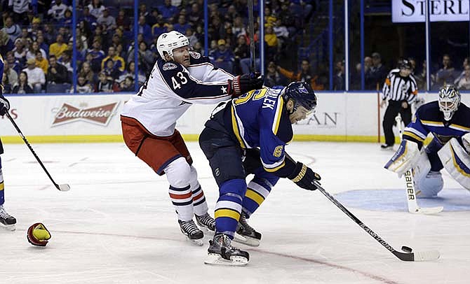 Columbus Blue Jackets' Scott Hartnell, left, loses a glove as he pushes St. Louis Blues' Zbynek Michalek, of the Czech Republic, during the third period of an NHL hockey game Saturday, March 28, 2015, in St. Louis. The Blue Jackets won 4-2.
