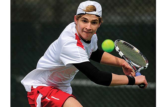 Jefferson City's Spencer Bone lunges for a backhand return during a doubles match with teammate David Clausen in Saturday's dual with Lee's Summit at Washington Park.