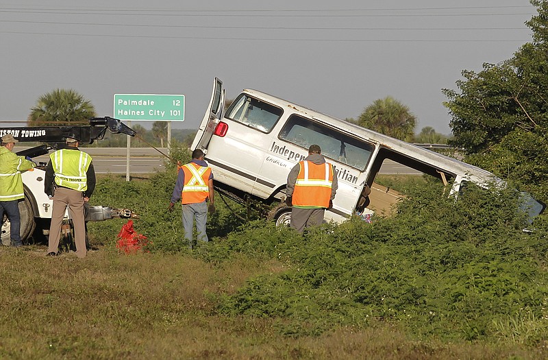 Workers pull a van out of a canal at the intersection of US 27 and State Road 78 West on Monday near Moore Haven, Fla. Eight people were killed and 10 injured when the church van ran through a stop sign, crossed all four lanes of a rural highway and crashed into in a canal.