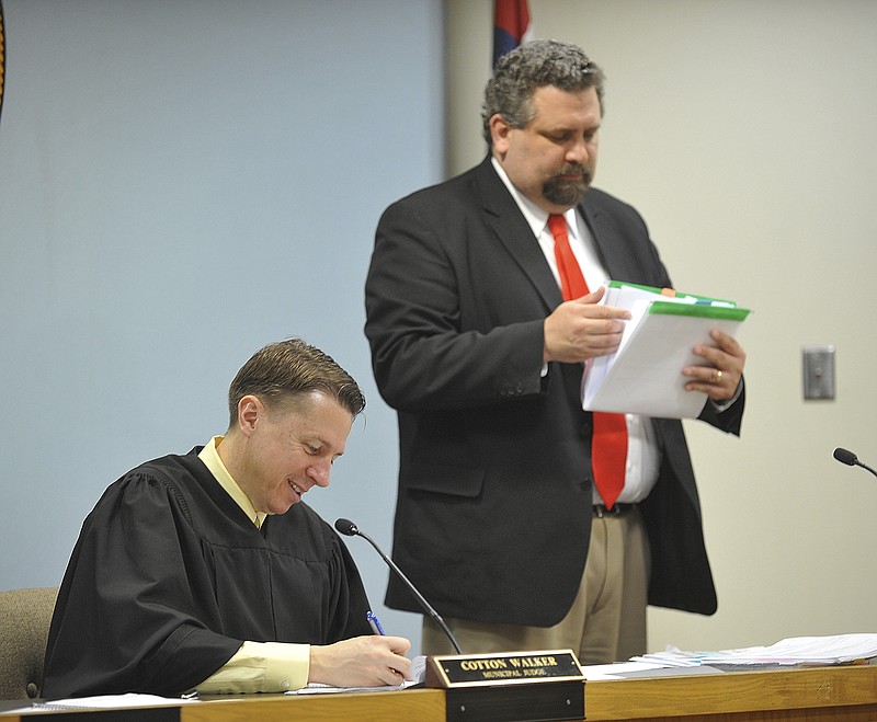 Municipal Judge, Cotton Walker, seated, and Municipal Prosecutor, Brian Stumpe, work through the stack of court cases on the agenda on Wednesday, March 18, 2015.