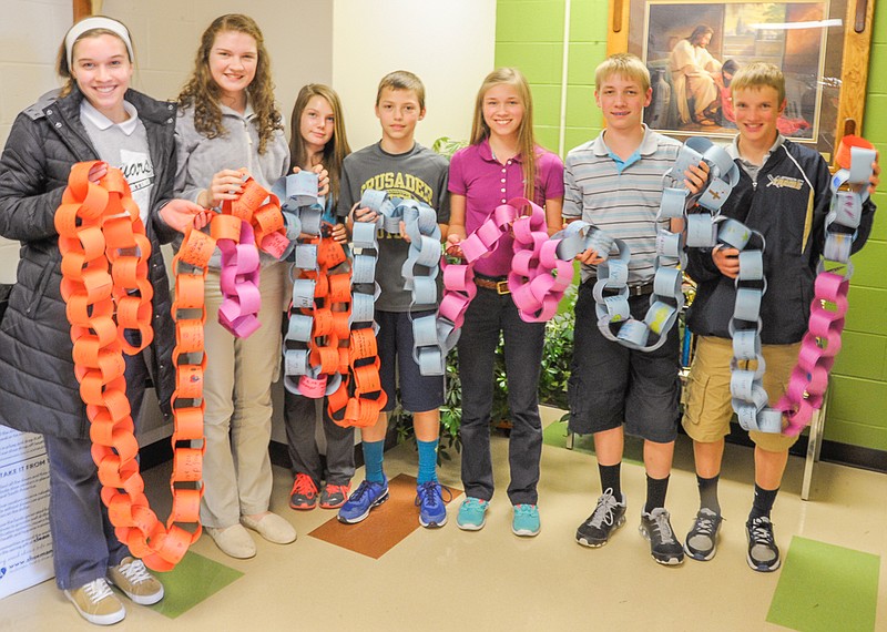 Student Council members at St. Martins Catholic School display a prayer chain created with construction paper links holding student prayers.