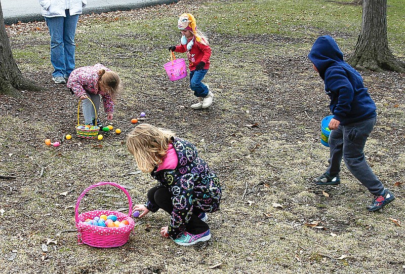 Several children in the 4-6 year old age group gather baskets of plastic Easter Eggs on Saturday.