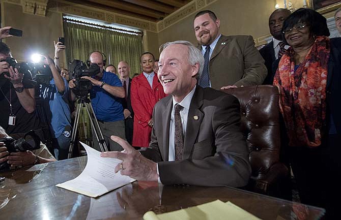 Arkansas Gov. Asa Hutchinson signs a reworked religious freedom bill into law after it passed in the House at the Arkansas state Capitol in Little Rock, Ark., Thursday, April 2, 2015.
