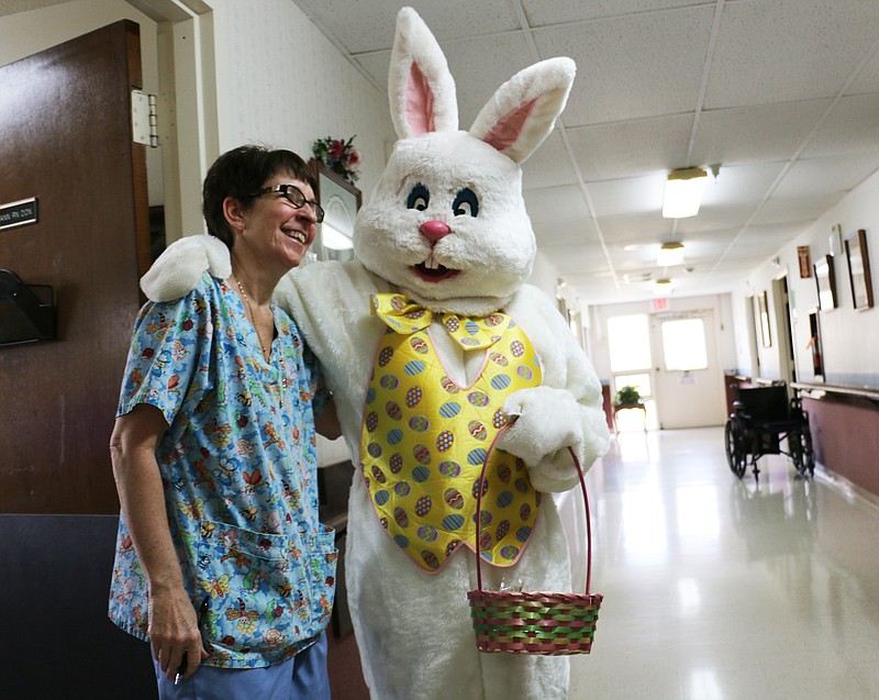 Kim Hegemann poses for a photo with the Easter Bunny at Fulton Manor Wednesday. Central Bank had the Easter Bunny hand out cookies at Fulton Manor. The bank will hold an Easter Egg Hunt at 10 a.m. Saturday in the grassy area near Moser's.