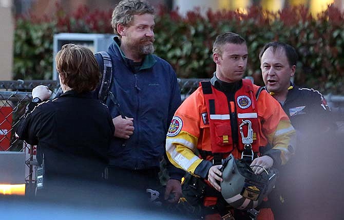 Louis Jordan, second from left, walks from the Coast Guard helicopter to the Sentara Norfolk General Hospital in Norfolk, Va., after being found off the North Carolina coast, Thursday, April 2, 2015. His family says he sailed out of a marina in Conway, S.C., on Jan. 23, and hadn't been heard from since.