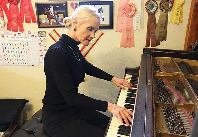 Deborah McAlexander plays a song she composed titled "On wings of prayer" in her Jefferson City home. She is legally blind, having lost all sight in one eye and most sight in the other. She will give a multimedia presentation Monday at William Woods University.