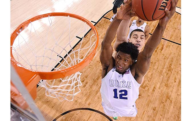 Duke's Justise Winslow (12) is fouled by Michigan State's Gavin Schilling, rear, during the second half of the NCAA Final Four tournament college basketball semifinal game Saturday, April 4, 2015, in Indianapolis.