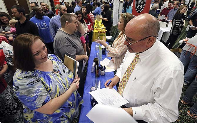Frances Scoggins, left, speaks to Michael McCall, general manager for Chattanooga Labeling Systems, about her resume during a huge 15-county North Georgia job fair at The Colonnade in Ringgold, Ga., on Thursday, April 2, 2015. Scoggins has been unemployed for the past 4-months and is looking for a safety or manufacturing job. The U.S. government issued its March jobs report on Friday, April 3, 2015, which seemed to indicate the economy's slump overtook the job market. (AP Photo/Chattanooga Times Free Press, Dan Henry)