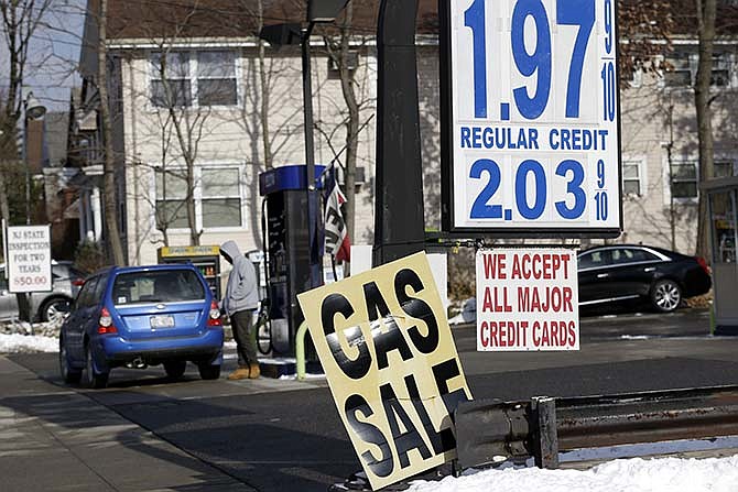 In this Jan. 9, 2015 file photo, an attendent pumps gas into a car at a service station in Leonia, N.J. Cheap gasoline is supposed to power consumer spending and falling unemployment is supposed to boost wages. Yet those common assumptions about how an economy thrives appear to have broken down during the first three months of 2015. 