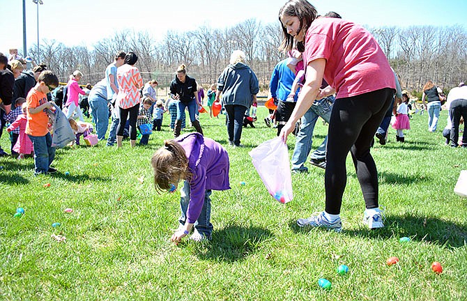 Children younger than 4 years old race to fill their bags and baskets with candy and prize-filled eggs Saturday during the Osage Beach Easter Egg Hunt at Osage Beach City Park.