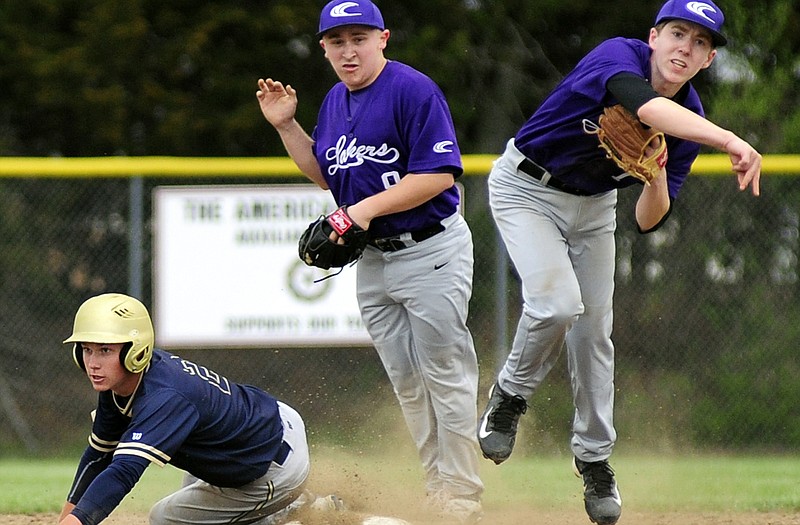 Helias baserunner John McDonald looks back for the call after trying to break up a double play relay throw by Camdenton's Brady Kempf in Monday night's game at the American Legion Sports Complex.