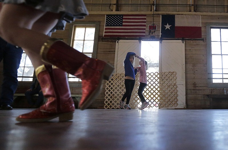Girls dance to fiddle music at Twin Sisters Dance Hall in Blanco, Texas. A preservation group says old Texas dance halls that for years served as important social centers in rural areas of the state are decaying and closing, with comparatively few still operating.