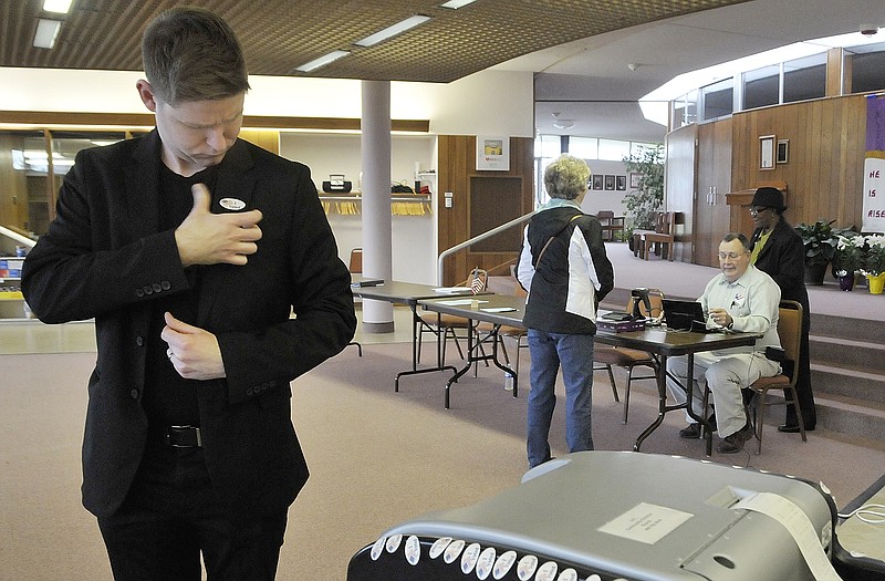 Jere Keefer adheres an "I Voted" sticker on his jacket after he placed his ballot into the reader Tuesday while voting at Community Christian Church on Ellis Boulevard.