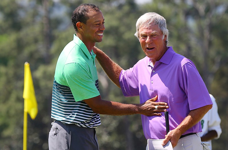 Tiger Woods and Ben Crenshaw embrace on the 18th green as they finish a practice round Wednesday for the Masters in Augusta, Ga.