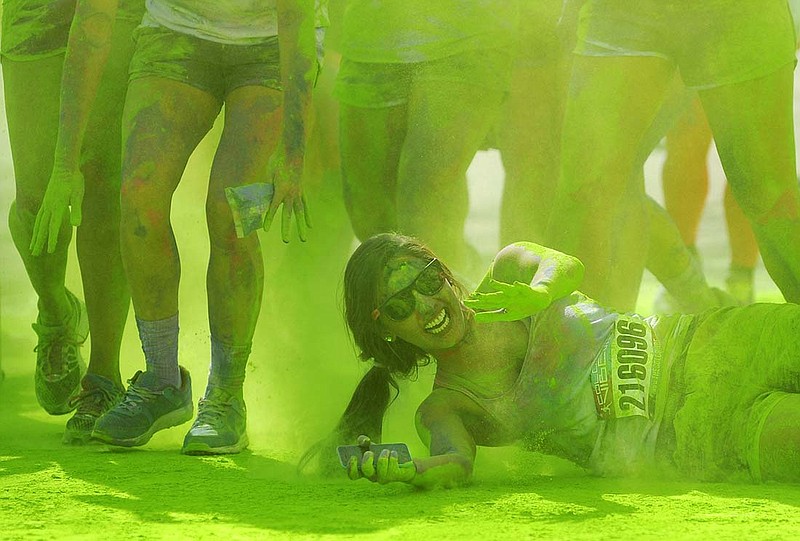 A runner decides to roll through the green color zone while participating in the 2014 Central Missouri Color Vibe 5k.