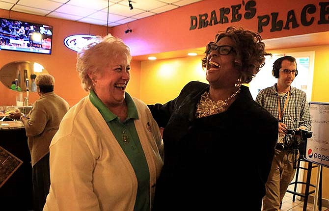 Ferguson City Council Candidate Ella Jones, right, is greeted by resident and supporter Tana Cofer on Tuesday at her election party Tuesday at Drake's Place in Ferguson, Mo.