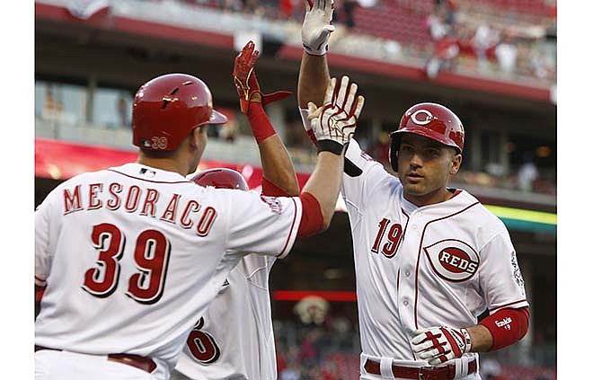 Cincinnati Reds' Joey Votto is congratulated by Devin Mesoraco (39) after Votto hit a two-run home run off St. Louis Cardinals starting pitcher John Lackey in the first inning of a baseball game, Friday, April 10, 2015, in Cincinnati.