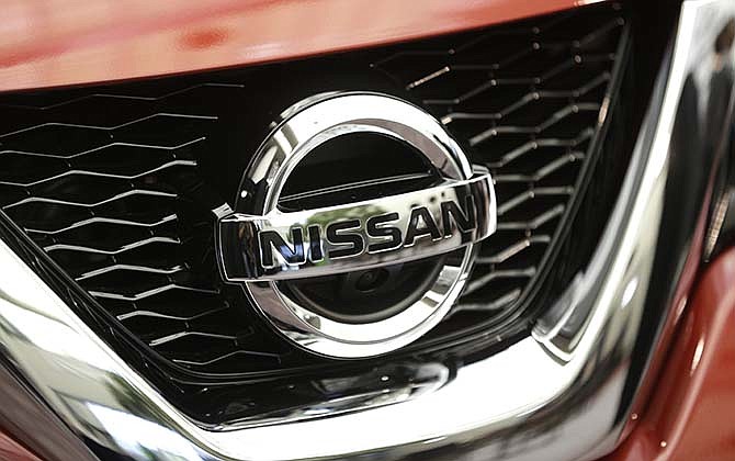 This Tuesday, Sept. 10, 2013, file photo shows the Nissan logo on a 2014 Rogue in Farmington Hills, Mich. Nissan and BMW are recalling more than 94,000 vehicles because the fuel pumps can fail and cause stalling. The recalls cover 76,000 Nissan Rogues from the 2014 model year and another 18,000 BMW 2, 3 and 4 series models from 2014 and some 4 series cars from 2015.