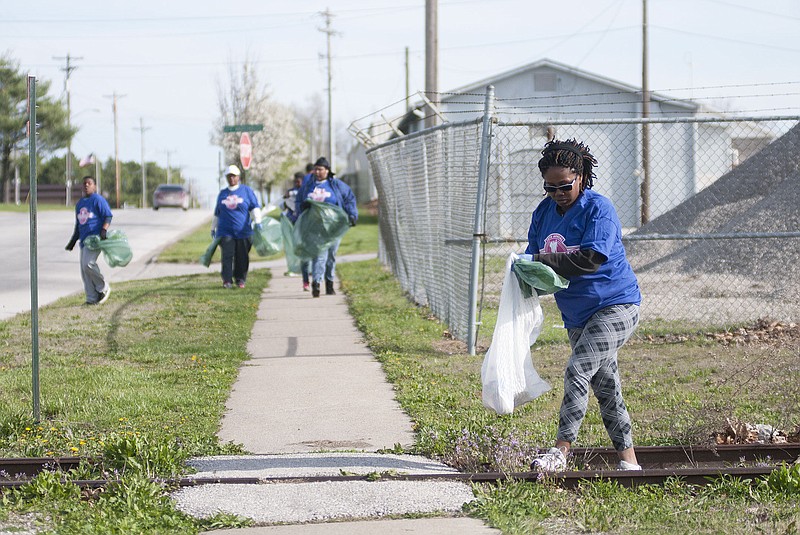 Deniece Vaughn-McCaleb, of Fulton, and members of Second Christian Church pick up trash on the side of Westminster Avenue on Saturday during the city of Fulton's 15th annual Clean Sweep.