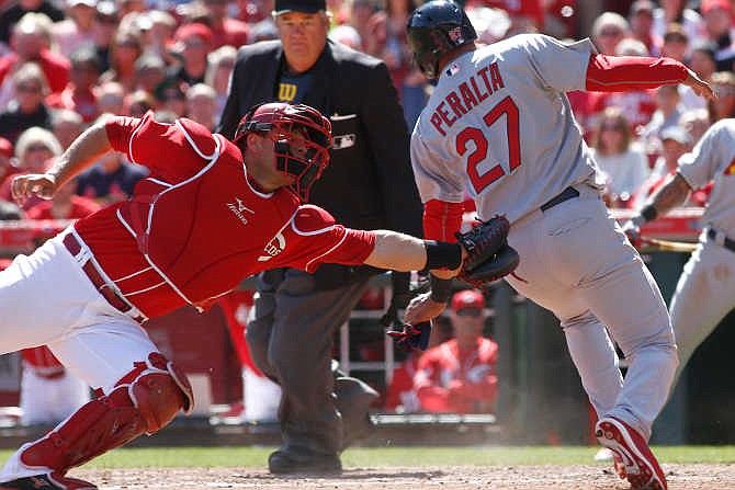 St. Louis Cardinals' Jhonny Peralta (27) is safe at home beating the tag from Cincinnati Reds catcher Devin Mesoraco, left, in the ninth inning of a baseball game, Saturday, April 11, 2015, in Cincinnati. The Cardinals won 4-1. 