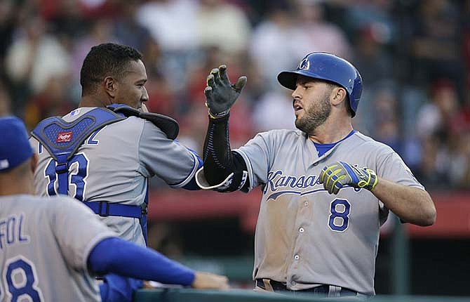 Kansas City Royals' Mike Moustakas, right, celebrates his home run with Salvador Perez during the fourth inning of a baseball game against the Los Angeles Angels, Saturday, April 11, 2015, in Anaheim, Calif.