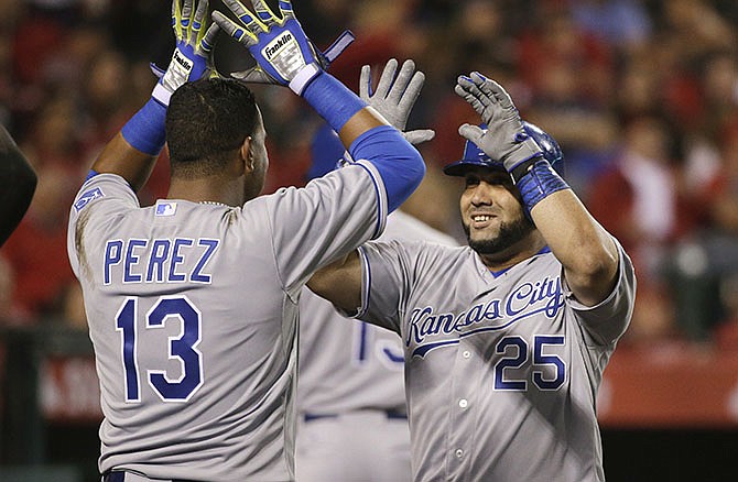Kansas City Royals' Kendrys Morales, right, celebrates his home run with Salvador Perez during the sixth inning of a baseball game against the Los Angeles Angels, Friday, April 10, 2015, in Anaheim, Calif. 