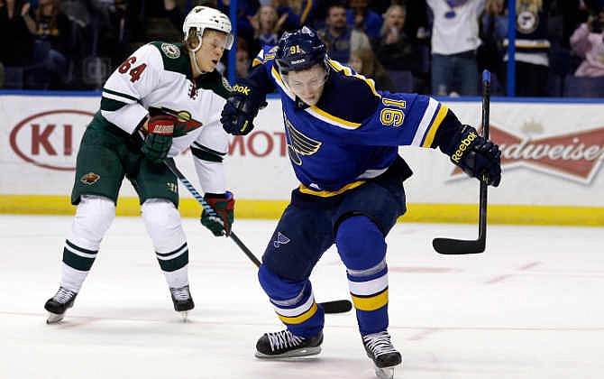 St. Louis Blues' Vladimir Tarasenko, right, of Russia, celebrates after scoring as Minnesota Wild's Mikael Granlund, left, of Finland, watches during the second period of an NHL hockey game Saturday, April 11, 2015, in St. Louis.