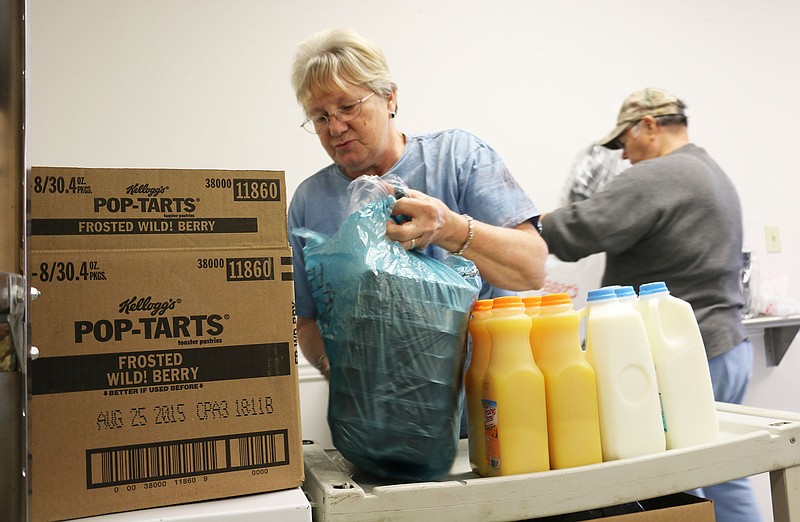 Charlotte and Nick Nichols pack up food and frozen meals at the Callaway County Senior Center Monday morning.