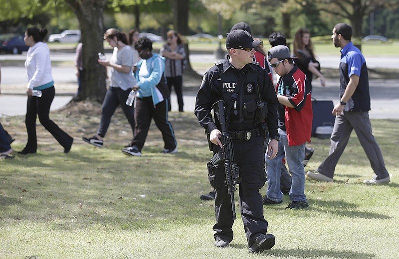 A police officer stands by Monday as students and faculty are allowed to return following a lockdown at Wayne Community College, in Goldsboro, N.C. One person was killed in a shooting at the community college that was locked down as authorities searched for a gunman, officials said.