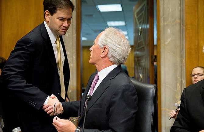 Senate Foreign Relations Committee Chairman Sen. Bob Corker, R-Tenn., center, shakes hands Republican presidential candidate Sen. Marco Rubio, R-Fla., left, after the Senate Foreign Relations Committee passes S.615, the Iran Nuclear Agreement Review Act of 2015, during a committee business meeting on Capitol Hill in Washington, Tuesday, April 14, 2015. Republican and Democrats on the Senate Foreign Relations Committee reached a compromise Tuesday on a bill that would give Congress a say on an emerging deal to curb Iran's nuclear program. 
