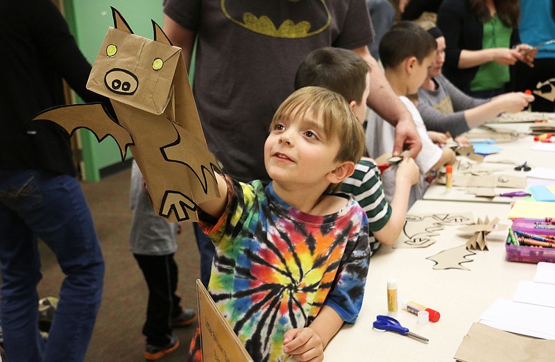 Michael Cole shows off his bat, which he made using paper lunch bags, at the Callaway County Public Library in Fulton Tuesday night. The library hosted bat-themed activities and read a bat-themed story.