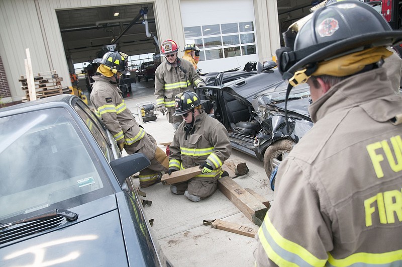 Fulton firefighters work together to place wood blocks underneath a Buick Century during vehicle extrication training on Wednesday at the Tennyson Fire Station.