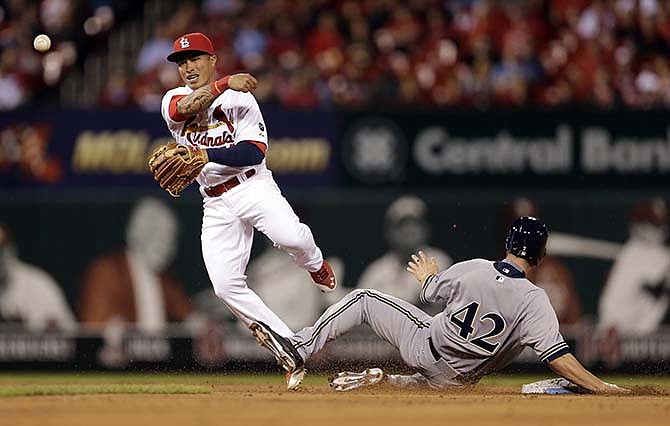 Milwaukee Brewers' Logan Schafer, right, is out at second as St. Louis Cardinals second baseman Kolten Wong fails to turn the double play during the ninth inning of a baseball game Wednesday, April 15, 2015, in St. Louis. The Brewers' Carlos Gomez was safe at first and the Cardinals went on to win 4-2. 