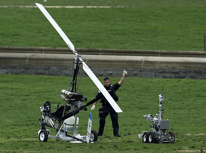 A Capitol Police officer flashes a thumbs up Wednesday after inspecting the small helicopter a man landed on the West Lawn of the Capitol in Washington. 