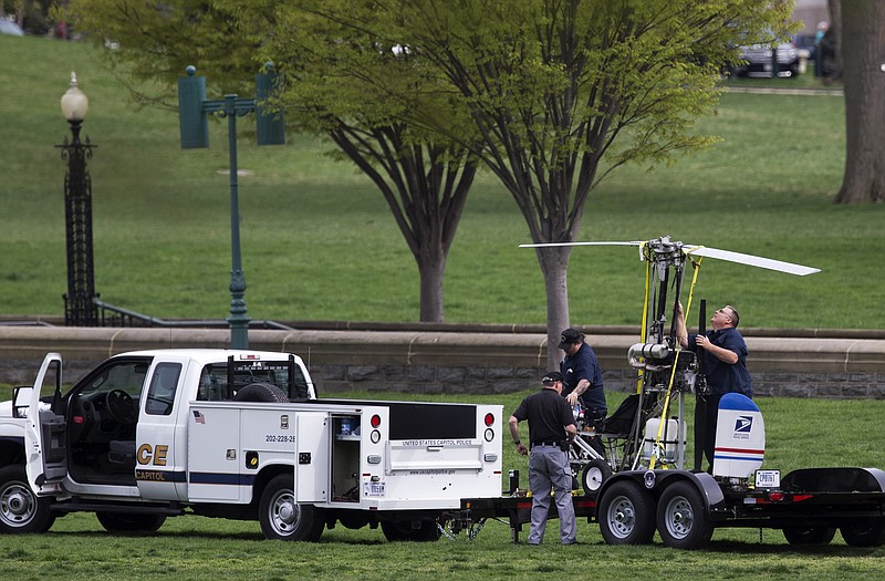 Capitol Police officers load a small helicopter onto a trailer, after a man landed on the West Lawn of the Capitol on Wednesday. Police arrested the pilot who evaded radar in the restricted airspace.
