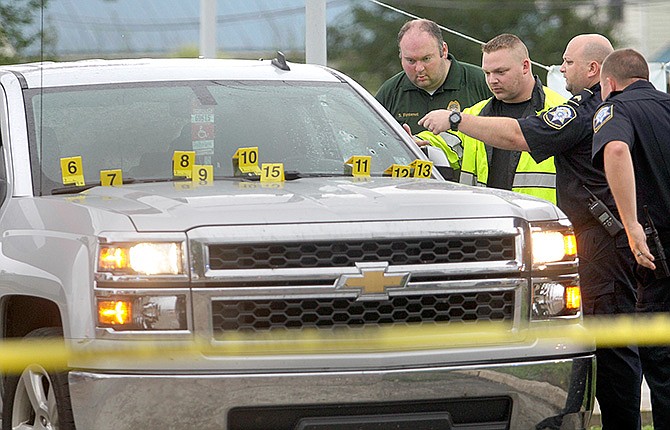 St. Charles Parish Sheriff's deputies investigate the scene where Cpl. Burt Hazeltine was shot multiple times while directing traffic in a school zone Thursday in Paradis, Louisiana.