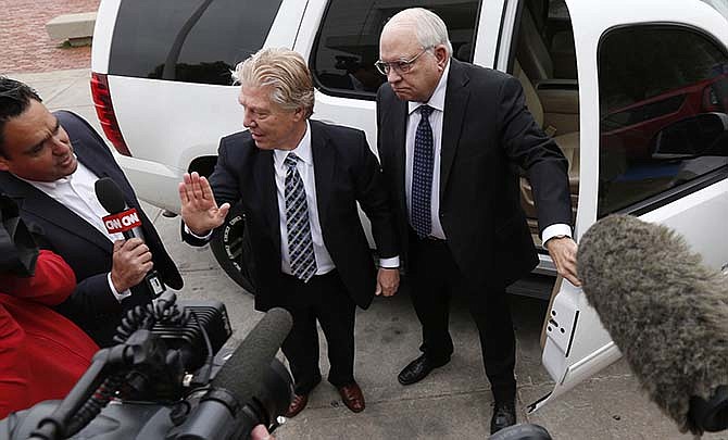 Robert Bates, right, arrives at the Tulsa County Jail with his attorney, Clark Brewster, Tuesday, April 14, 2015, in Tulsa, Okla. Bates, a 73-year-old Oklahoma volunteer sheriff's deputy who authorities said fatally shot a suspect after confusing his stun gun and handgun, was booked into the county jail Tuesday on a manslaughter charge. 