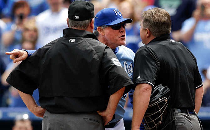 Kansas City Royals manager Ned Yost, back, argues with umpires Greg Gibson, right, and Jim Joyce, left, during the first inning of a baseball game against the Oakland Athletics at Kauffman Stadium in Kansas City, Mo., Sunday, April 19, 2015. Yost was ejected from the game. 