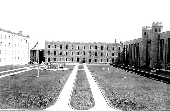 This pre-1954 riot photo of the MSP quadrangle shows Housing Unit 3, right, A Hall, left, and the dining hall, later the education building, center. The middle building was burned to the ground during the riots. The fountain and walkways were once lined with meticulous flower beds.