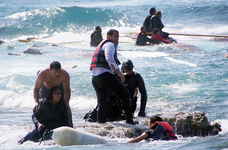 A man rescues an migrant from the Aegean sea, in the eastern island of Rhodes, on Monday after a wooden boat carrying dozens of migrants ran aground off the island.