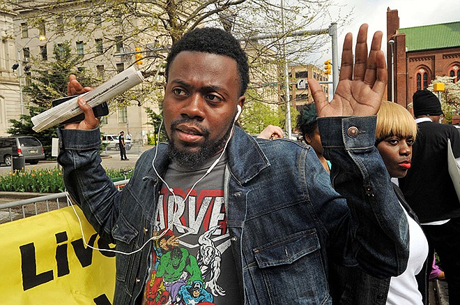 William Stewart, a friend of Freddie Gray, protests Monday outside City Hall in Baltimore. The city's top police officials, mayor and prosecutor sought to calm a "community on edge" while investigating how Gray suffered a fatal spine injury while under arrest.