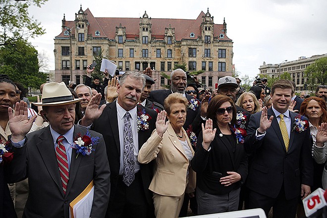 Members of the St. Louis Board of Aldermen are given the oath of office Tuesday in a park across the street from City Hall in St. Louis. The ceremony was moved outside after City Hall was evacuated Tuesday when two suspicious cylinders and a bag were found at three entrances to the sprawling government building downtown.