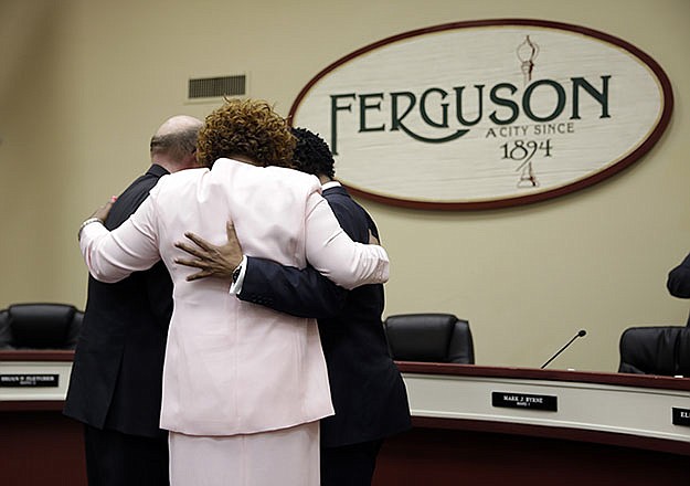 Three newly elected members of the Ferguson City Council, from left, Brian Fletcher, Ella Jones and Wesley Bell, embrace after being sworn in during a monthly meeting of the council Tuesday.
